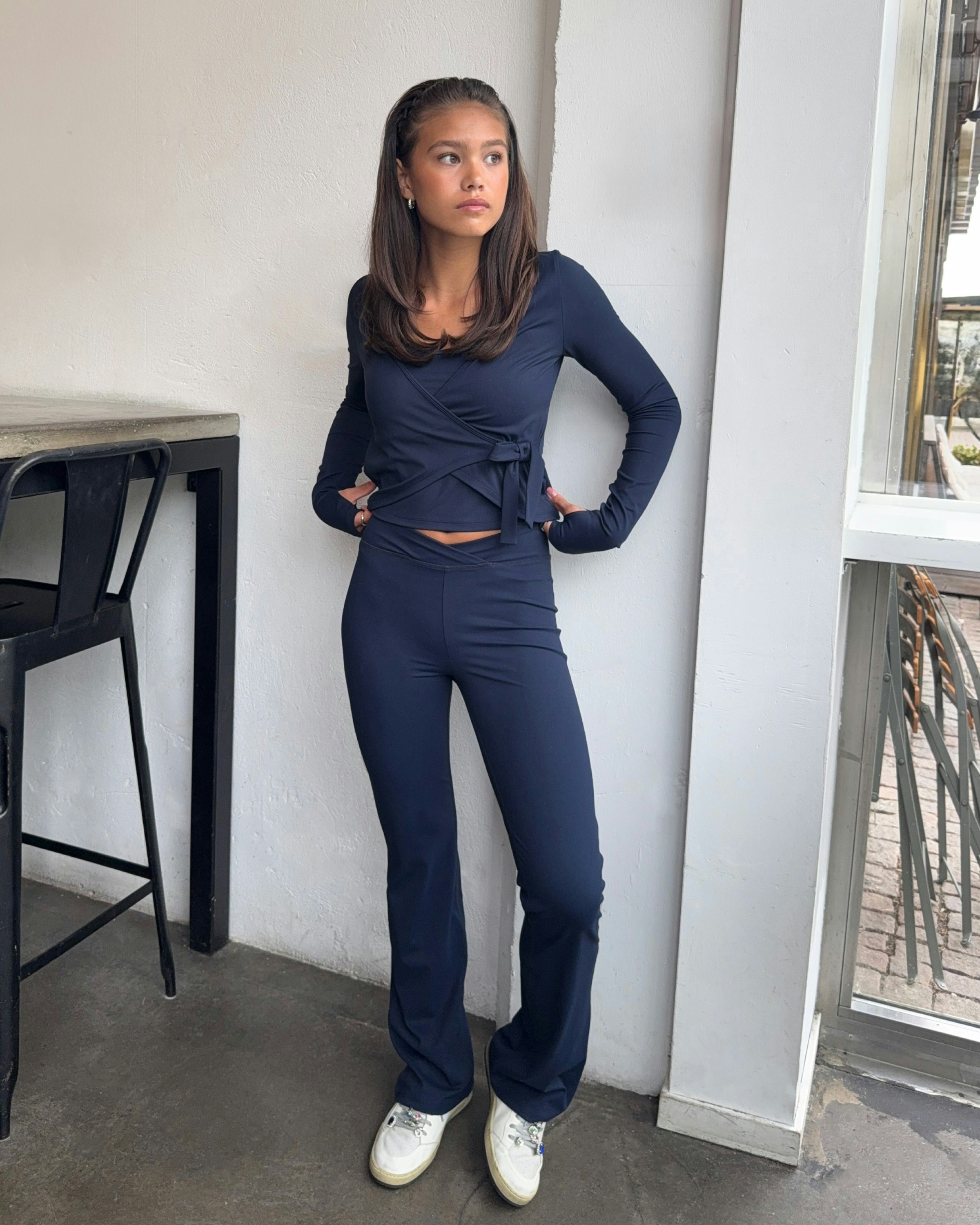 Donkerblauwe aansluitende wikkel-top met bijpassende flared broek – perfect voor dagelijks gebruik.