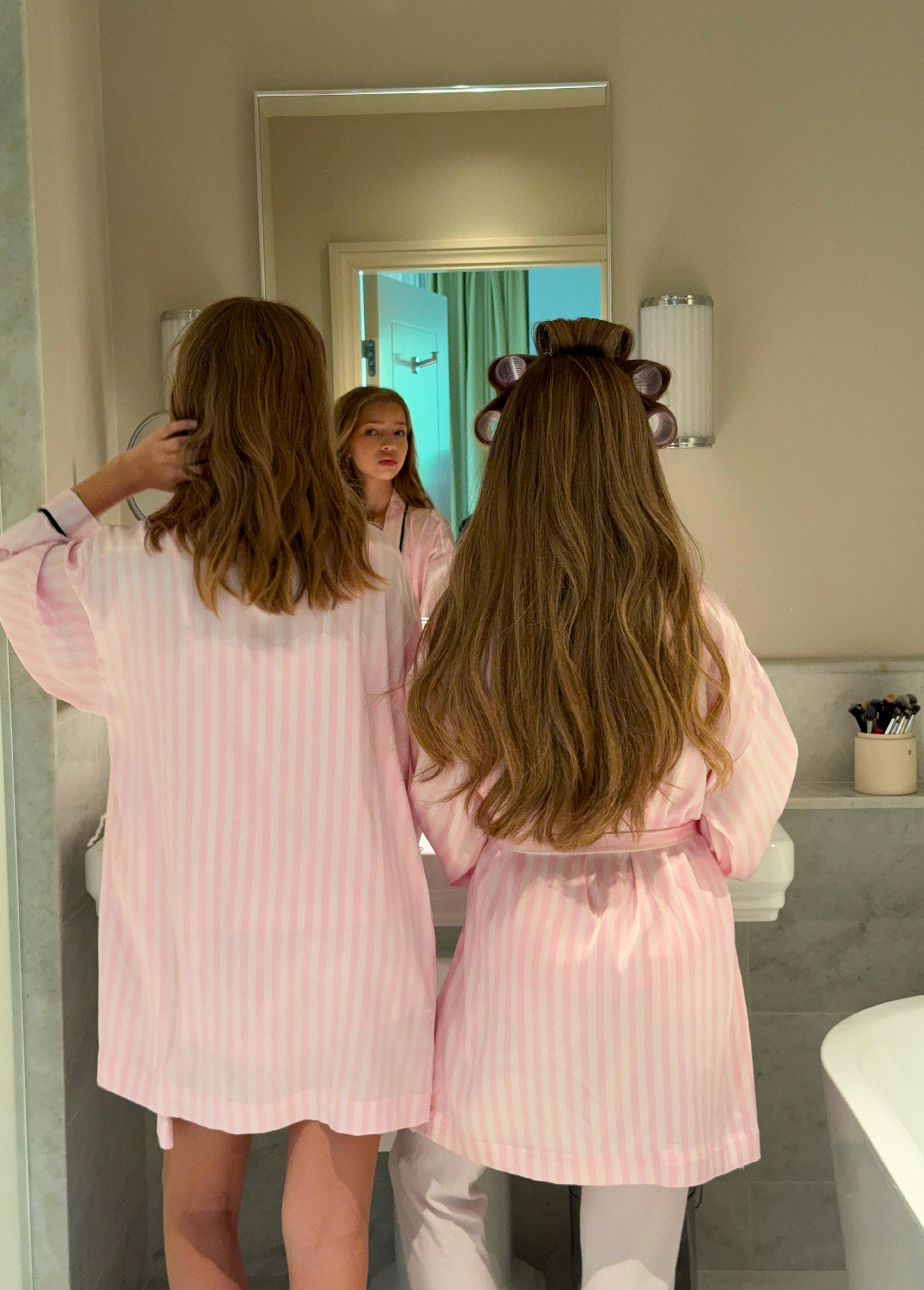 Stripet rosa pysj og morgenkåpe i baderom – for en luksuriøs morgenrutine.
